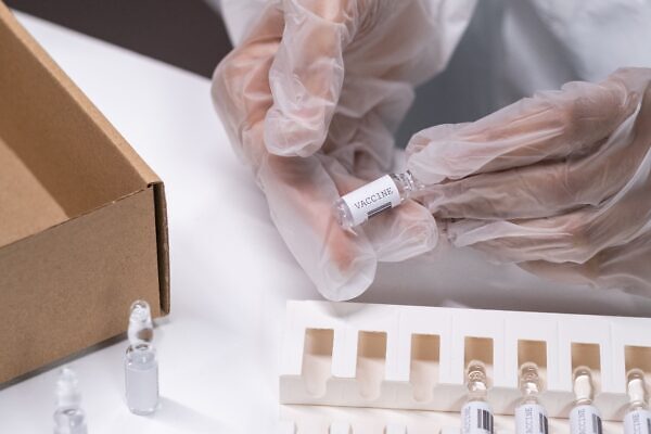 Personal de laboratorio manipula un vial durante una actividad de investigación farmacéutica.