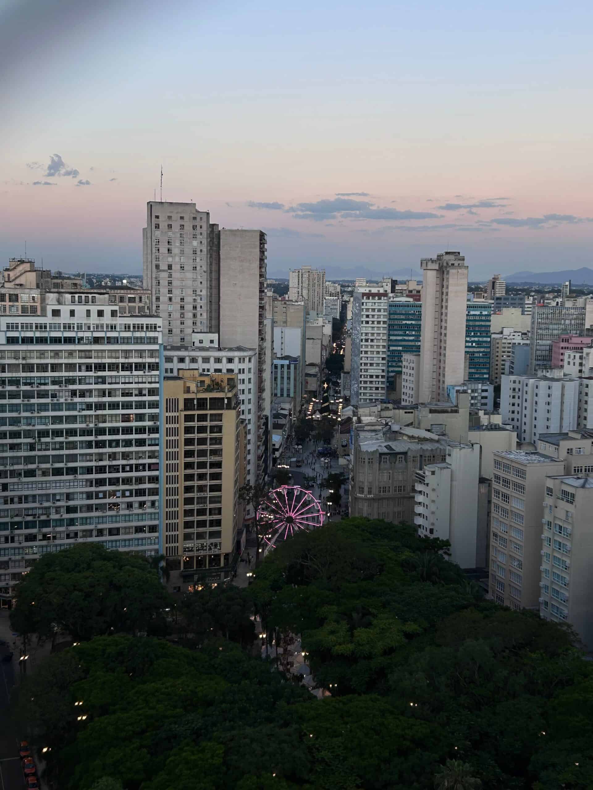 Vista de la ciudad de Curitiba con calles sin cables a la vista y un parque en primer plano.