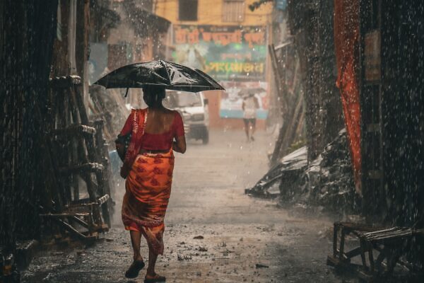 El monzón: el fenómeno que da vida a India y también pone a prueba su resistencia Una mujer con un sari camina con un paraguas a través de un callejón empapado de lluvia en Kolkata, India.