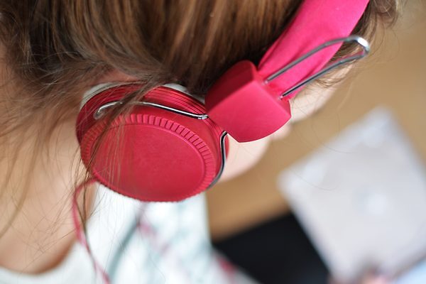 mujer escuchando música con audífonos rojos