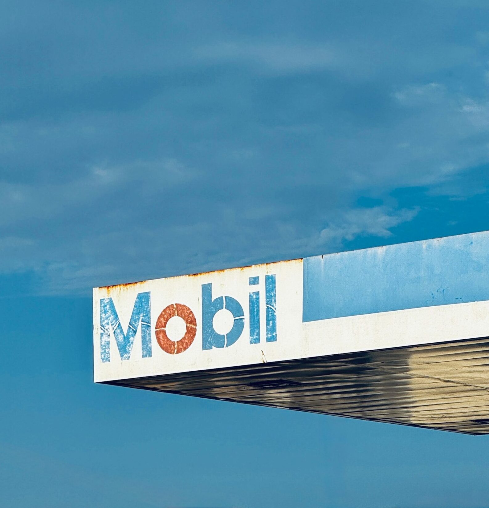 Una cubierta de gasolinera Mobil fotografiada bajo un cielo azul claro en contexto del petróleo de Venezuela
