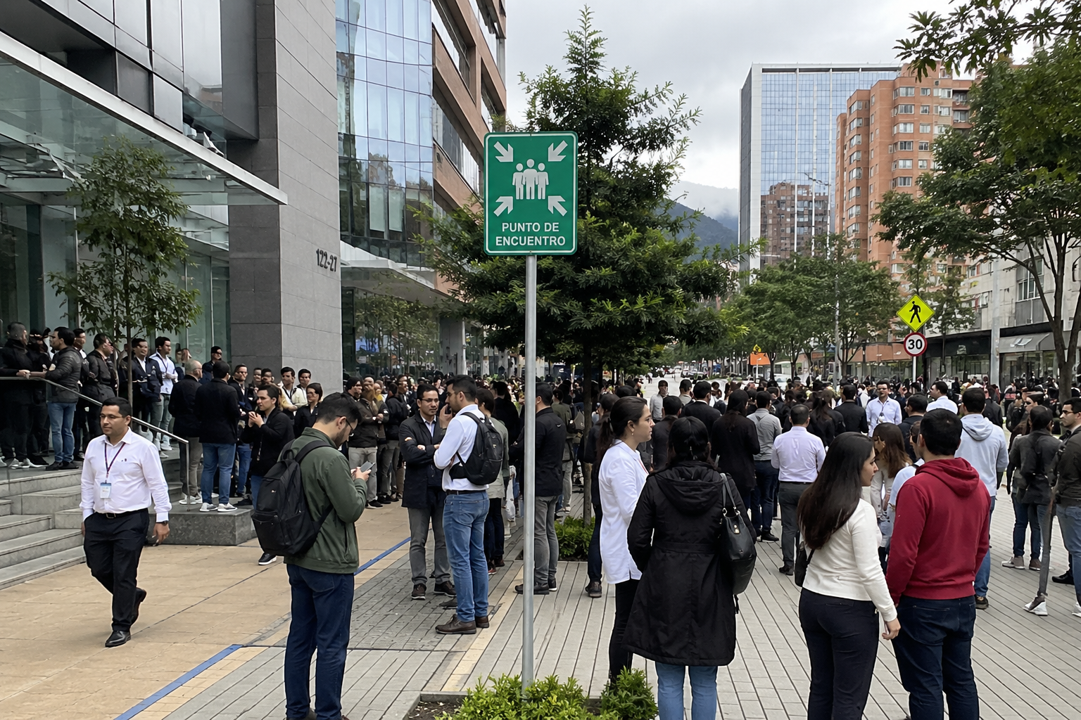 Multitud de personas en Santander evacuando edificios tras un sismo de 5,1, con señalización de punto de encuentro visible.