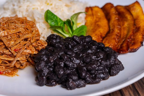 plato con caraotas, carne desmechada, platano y arroz