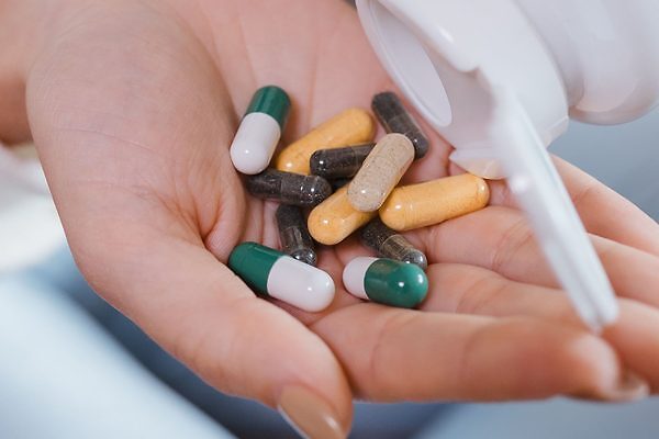 una mano con sumplementos alimenticios